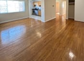 Thumbnail 8 of 8 - A room with wooden floors and white walls.