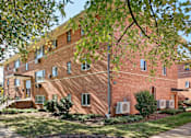 Thumbnail 3 of 16 - A red brick building with trees in front.