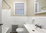 Thumbnail 14 of 15 - A white toilet sits under a window in a bathroom.