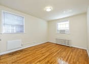 Thumbnail 11 of 15 - A room with wooden floors and a window with blinds.