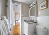 Thumbnail 15 of 18 - A bathroom with a white toilet, sink, and mirror.