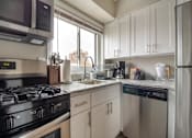 Thumbnail 9 of 18 - A modern kitchen with a stove, microwave, and dishwasher.