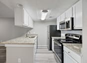 Thumbnail 14 of 42 - A kitchen with white cabinets and a granite countertop.