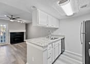 Thumbnail 16 of 42 - A kitchen with a white countertop and a black refrigerator.