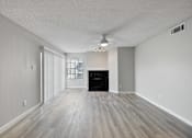 Thumbnail 22 of 42 - A spacious room with a fireplace and wood flooring.