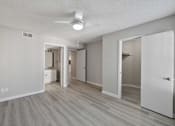 Thumbnail 33 of 42 - A spacious room with a ceiling fan and light, hardwood floors, and white walls.