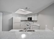 Thumbnail 17 of 42 - A kitchen with white cabinets and appliances.