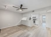 Thumbnail 8 of 42 - A spacious kitchen and living room with a ceiling fan and lighting fixture.