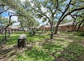 Thumbnail 16 of 18 - A backyard with a fence, a tree, and a house in the background.