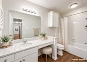 Thumbnail 6 of 18 - A white bathroom with a vanity, toilet, and shower.