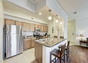 Thumbnail 2 of 21 - A modern kitchen with a large island and wooden cabinets.