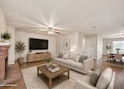 Thumbnail 1 of 18 - A living room with a fireplace and a flat screen TV.