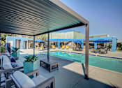 Thumbnail 67 of 71 - A pool area with a canopy and lounge chairs.