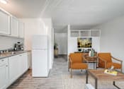 Thumbnail 5 of 28 - A kitchen with white cabinets and a white refrigerator with a dining area with orange chairs and a painting on the wall.