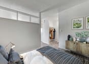 Thumbnail 3 of 28 - A bedroom with a bed, pillows, a lamp, and a wooden cabinet.