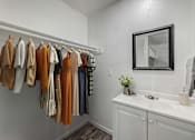 Thumbnail 4 of 28 - A row of clothes hanging on a rail in a white room.