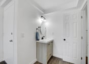 Thumbnail 11 of 56 - A white bathroom with a sink and a mirror.