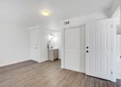 Thumbnail 14 of 56 - A room with white doors and a cabinet with a lamp on it.
