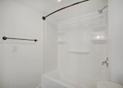 Thumbnail 12 of 56 - A white bathroom with a tub and toilet.