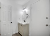 Thumbnail 16 of 56 - A white bathroom with a sink and a mirror.