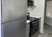 Thumbnail 22 of 56 - A modern kitchen with a stainless steel refrigerator and oven.