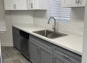 Thumbnail 20 of 56 - A kitchen with a sink and cabinets.