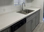 Thumbnail 18 of 56 - A kitchen with white cabinets and a black dishwasher.