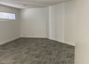 Thumbnail 21 of 56 - A room with wooden flooring and white walls.