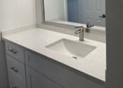 Thumbnail 15 of 56 - A bathroom with a sink and mirror.