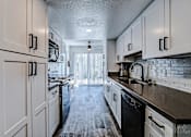 Thumbnail 23 of 56 - A kitchen with white cabinets and black appliances.