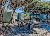 Thumbnail 40 of 56 - A picnic table is surrounded by trees in a courtyard.