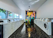 Thumbnail 49 of 56 - A laundromat with a row of washers and dryers.