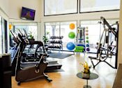 Thumbnail 55 of 56 - A gym with a row of treadmills and a row of exercise bikes.