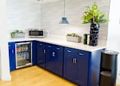 Thumbnail 56 of 56 - A kitchen with blue cabinets and a white countertop.