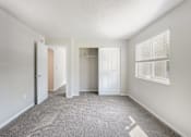 Thumbnail 14 of 15 - A room with a carpeted floor and two white doors.