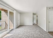 Thumbnail 12 of 15 - A spacious room with a carpeted floor and white walls.
