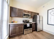Thumbnail 10 of 15 - A kitchen with brown cabinets and a white refrigerator.