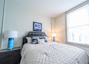 Thumbnail 12 of 15 - A bedroom with a large bed and two blue lamps.