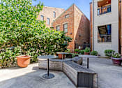 Thumbnail 2 of 23 - A patio with a table and chairs surrounded by potted plants.