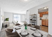 Thumbnail 2 of 15 - A dining room with a table set for four.