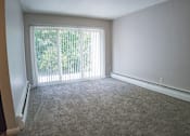 Thumbnail 3 of 8 - A room with a carpeted floor and a sliding glass door.