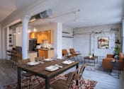 Thumbnail 9 of 19 - A dining room with a wooden table and chairs.