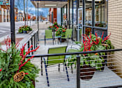 Thumbnail 5 of 10 - A balcony with a table and chairs surrounded by plants.