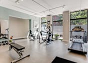 Thumbnail 11 of 23 - A gym with a variety of equipment including treadmills, weights, and exercise machines.