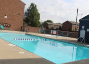 Thumbnail 16 of 17 - a swimming pool with a brick building and a fence around it
