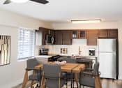 Thumbnail 18 of 18 - A modern kitchen with a dining table and chairs.