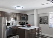 Thumbnail 12 of 18 - A modern kitchen with stainless steel appliances and wooden cabinets.