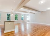 Thumbnail 10 of 23 - A large empty room with wooden floors and a ceiling fan.