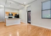 Thumbnail 8 of 23 - A kitchen with wooden floors and white walls.