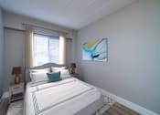 Thumbnail 7 of 10 - A bedroom with a large bed and a painting on the wall.